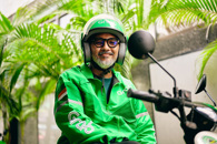 a man wearing a green helmet and glasses sitting on a motorcycle