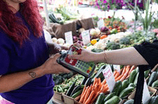 Person purchasing fresh fruits and vegetables