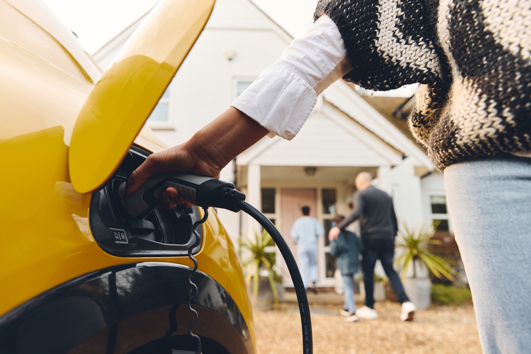 Man walking into home after charging EV