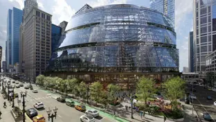 The Google Thompson Center in Chicago, a 17-storey, glass fronted building set to a backdrop of cars and greenery. 