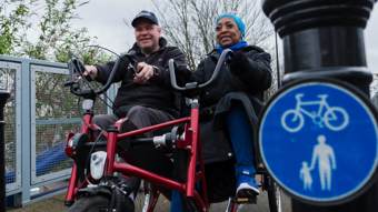 Man and woman using adapted bike on walking and cycling path