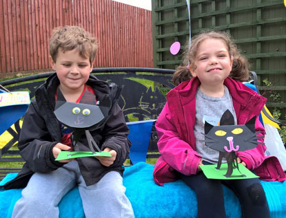 boy and girl holding paper cat craft project