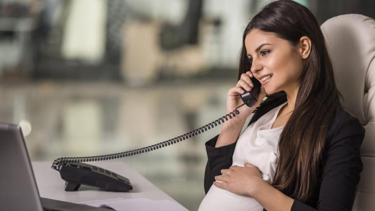 pregnant woman holding telephone