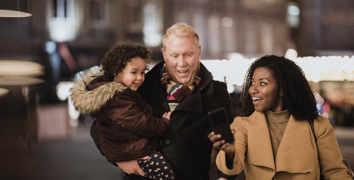 Couple walking with dad carrying child all in their coats