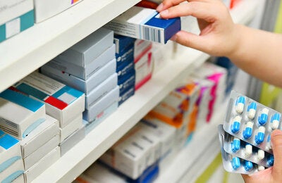 Pharmacist holding medicine box and capsule pack stock photo