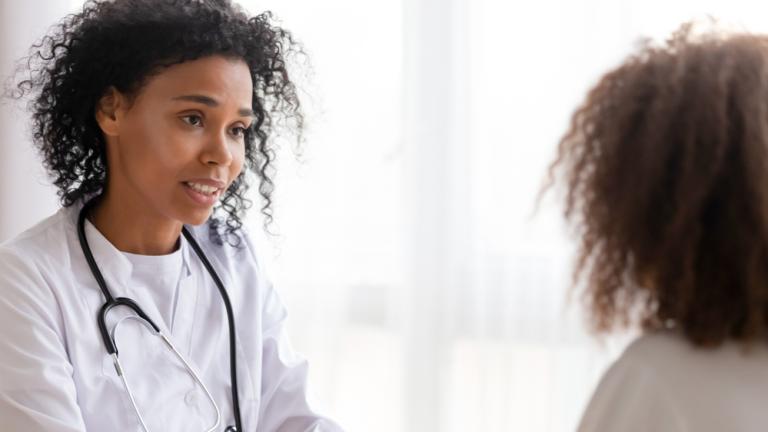 A physician talks to a young patient. 