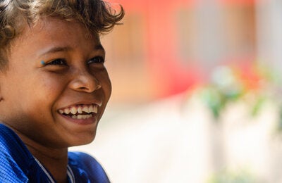 Indigenous girl smiling, with a blurred background