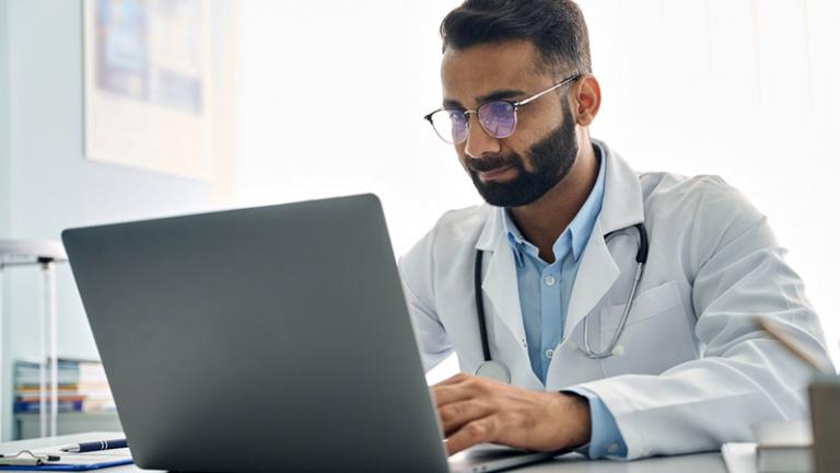 A doctor reviews data while working at the hospital.