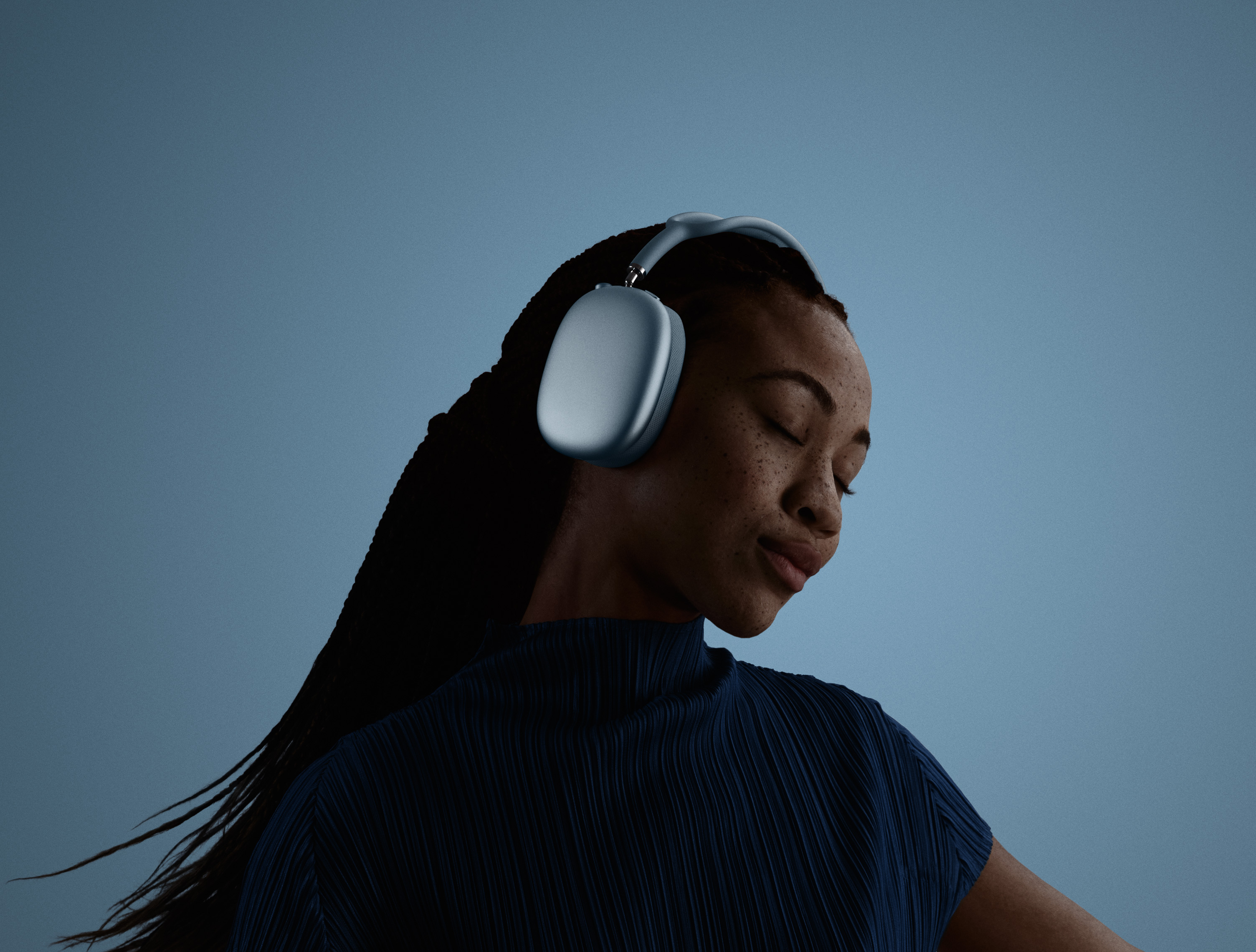 A woman with her eyes closed and head tilted to the left, wearing AirPods Max.