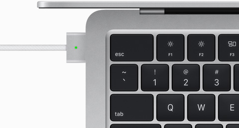 มุมมองด้านบนแสดงสาย MagSafe ที่เสียบเข้ากับ MacBook Air สีเงิน