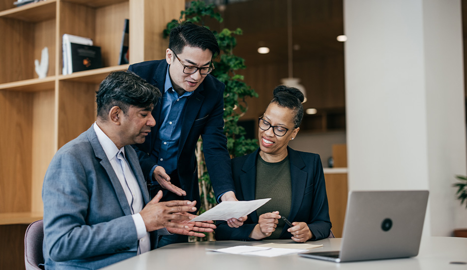 3 people using a laptop computer to access Equifax's cloud-based solutions.