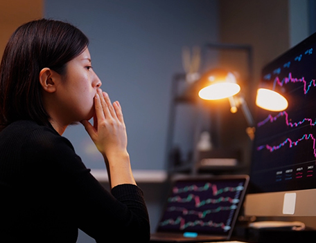 Woman looking at two computer screens