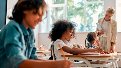 2022-23 Long-Term Trend Report: Students writing with pencils in classroom.