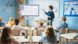 Teacher instructing students in a public school classroom.