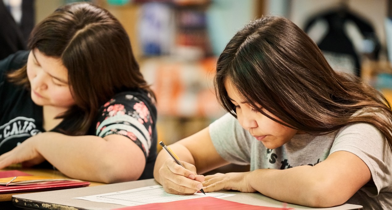 students writing at desk.