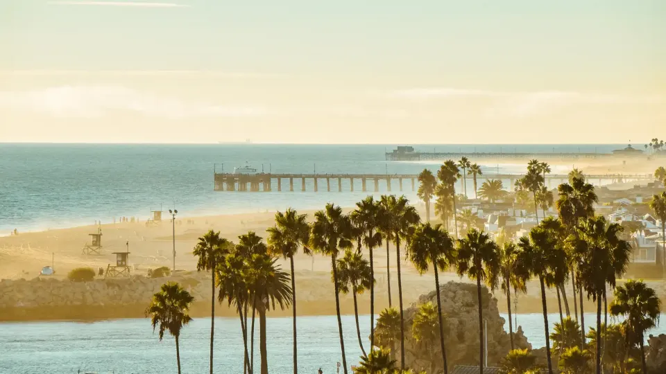 California beach with lifeguard stands and piers in late afternoon summer haze