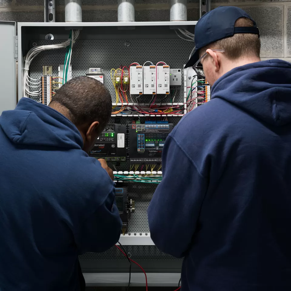 Two people looking at a control panel.