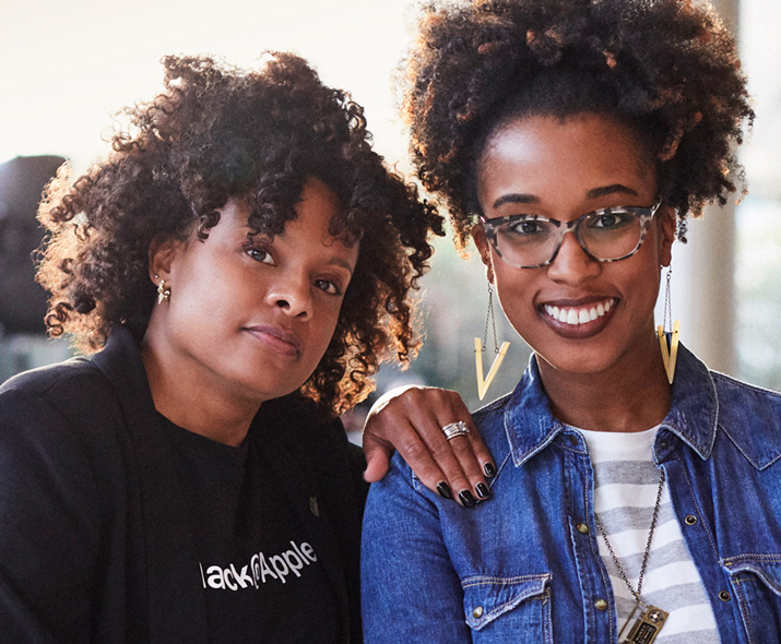 Photo de deux femmes de face, l’une semble très confiante, l’autre sourit.