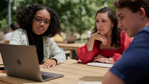 Twee studenten die buiten zitten bij een Apple campus.