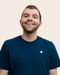 Persona del equipo de Apple Retail con la cabeza un poco inclinada hacia arriba y sonriendo.