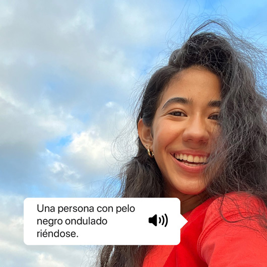 VoiceOver describiendo una foto y mostrando el texto leído. «Una persona con pelo negro ondulado riéndose.»