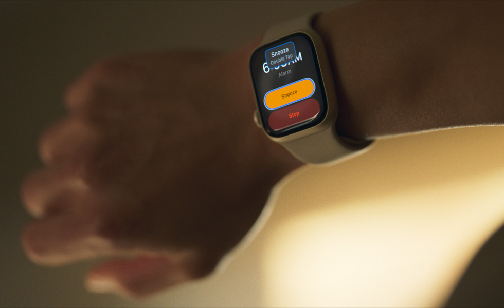 An arm with an Apple Watch. It says “Snooze, double tapˮ on the screen.