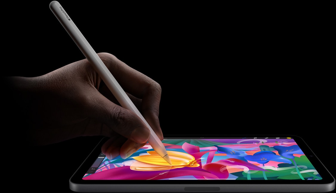 Apple Pencil Pro i handen på användare som skapar ett färgglatt konstverk på en iPad mini.