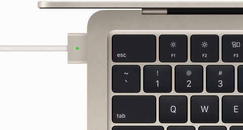 Vue de haut montrant un câble MagSafe relié à un MacBook Air en finition lumière stellaire