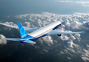 777X in flight over clouds and mountains