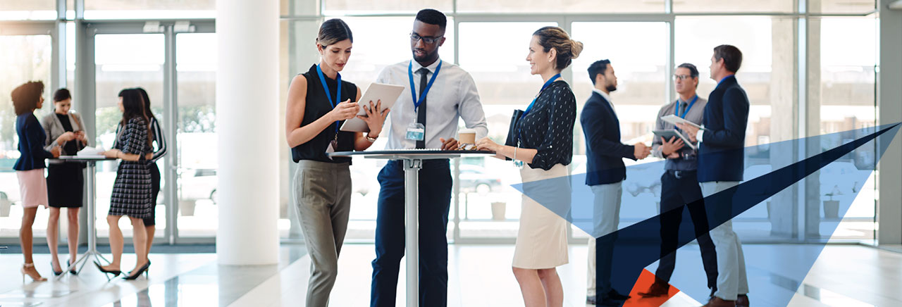 People in a bright room standing at a desk looking at documents