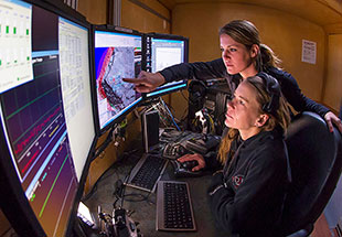 Picture of staff and of array of computer screens.