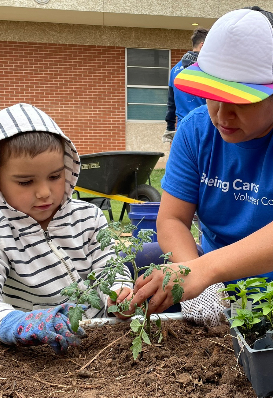 Mentor and child planting plants