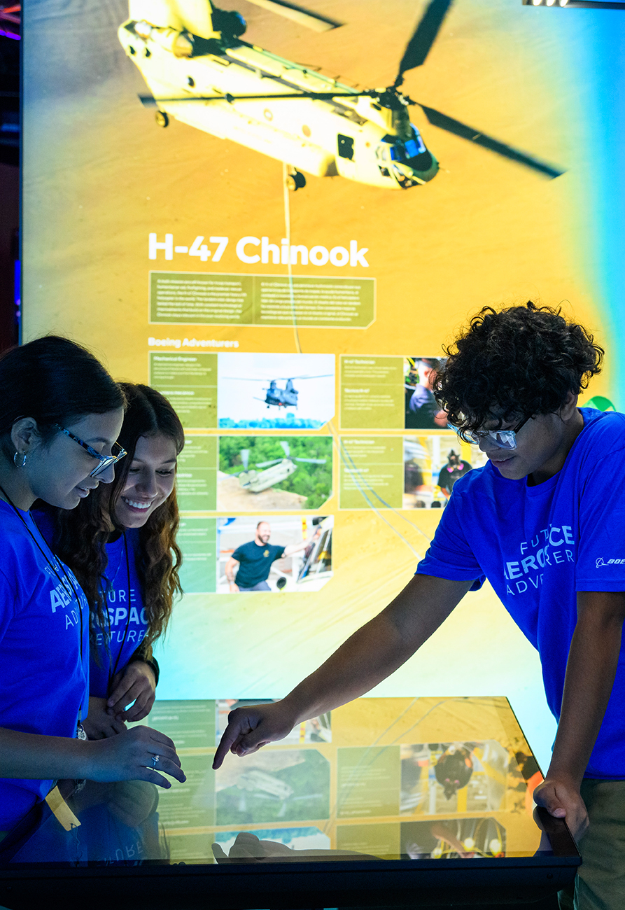 Young people looking over H-47 Chinook imagery