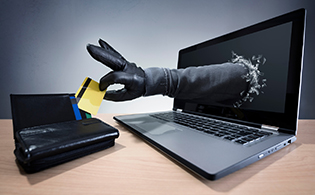 Hand greift aus Laptop in Brieftasche