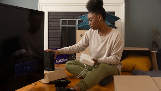 Student self-installing her internet modem and eero in her living room.