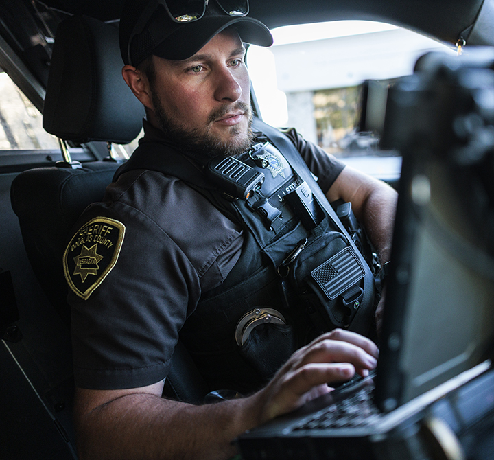 A member of the Douglas County Sheriff Department uses the laptop in his connected car before making his way to the next call in Douglas County Nebraska.