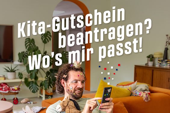 Ein Papa hat eine Krone auf dem Kopf sowie Sticker im Gesicht und hält ein Smartphone in der Hand. Auf dem Bild steht: Kita-Gutschein beantragen? Wo's mir passt!