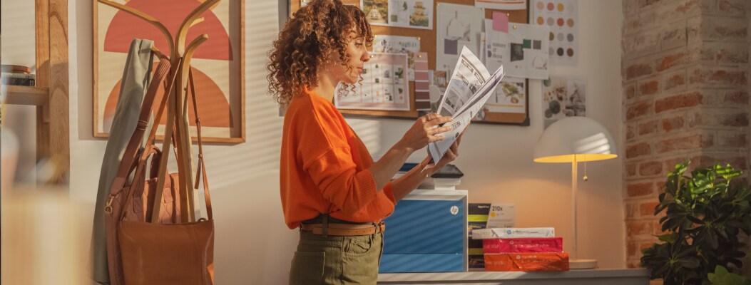 Woman in office reading a printed documents with HP LaserJet Pro in background