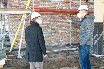 zwei Personen mit Schutzhelmen auf Baustelle