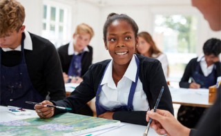 This image shows a group of school pupils painting in class. 