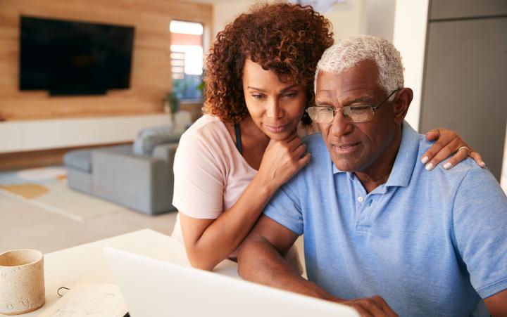 Senior couple looking at a laptop computer together.