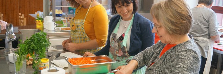 Workshop-Teilnehmerinnen putzen und scheiden Möhren. 