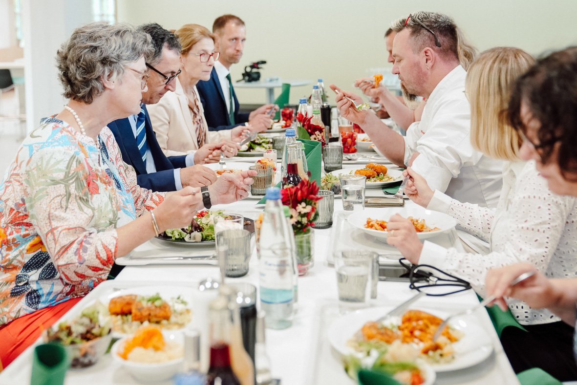 Cem Özdemir und andere sitzen an einem Tisch und essen