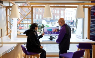 Staff helping a customer at a computer in a branch