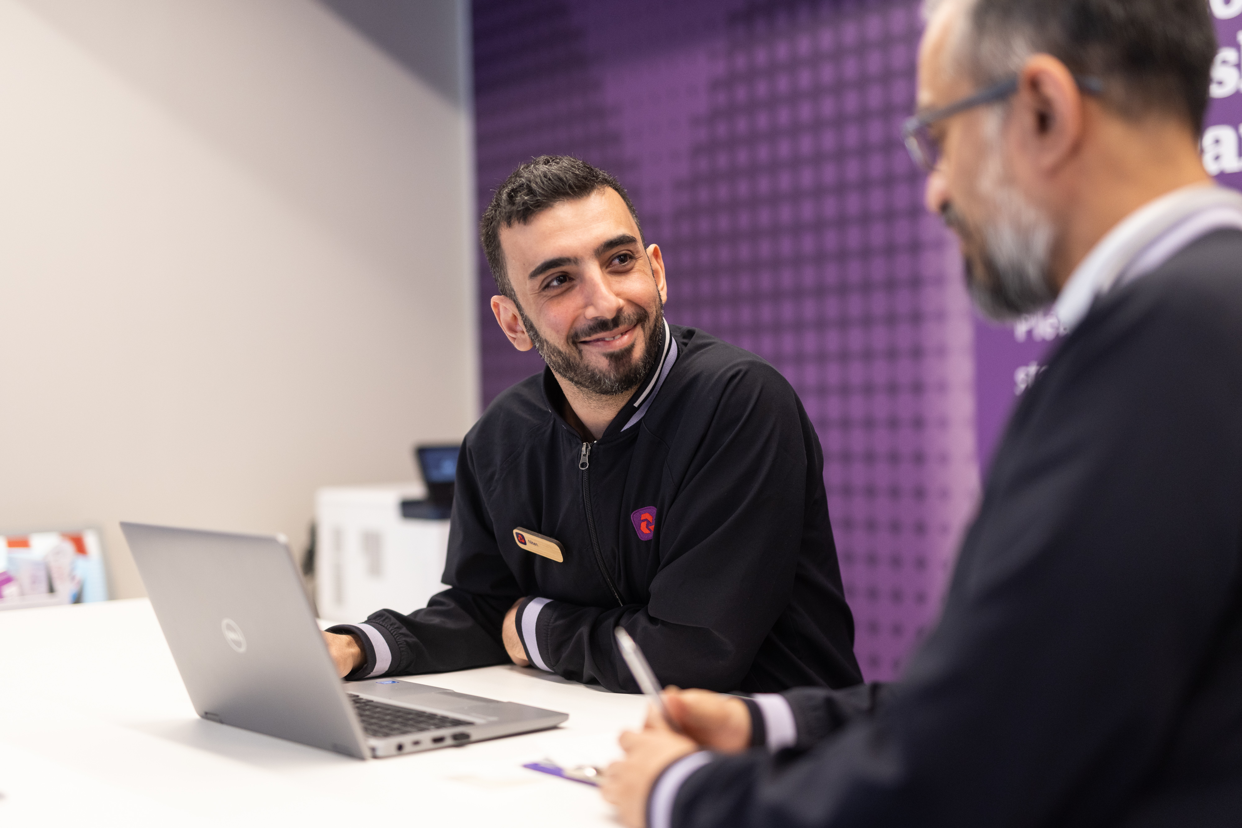 This image shows NatWest colleagues in a branch serving customers. 