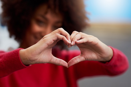 Woman holding hands in heart shape