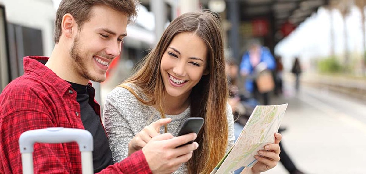 Ein junger Mann und eine junge Frau schauen sich einen Stadtplan an