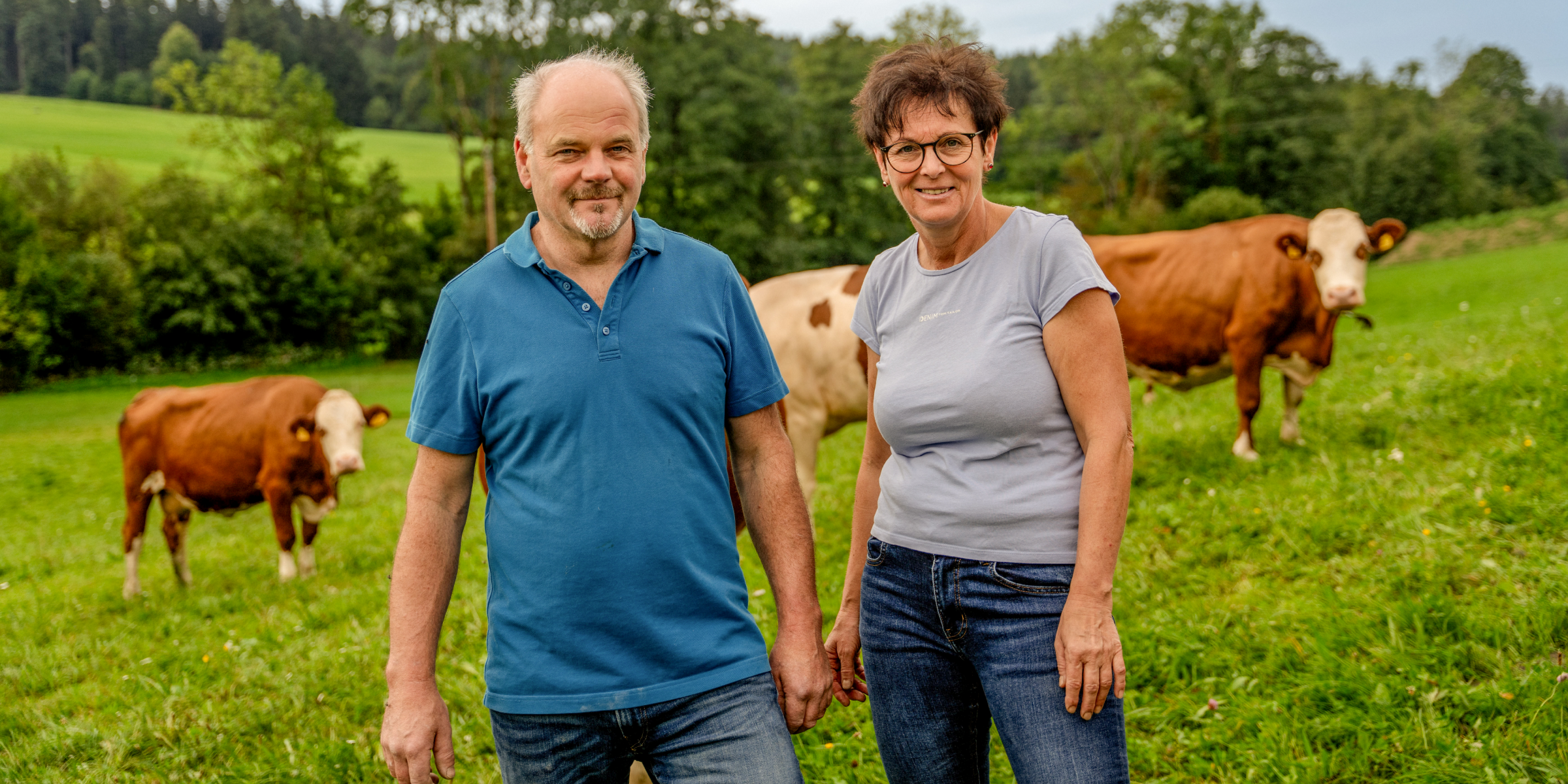 NFamilie Lechner stehtt vor einer Kuhherde.