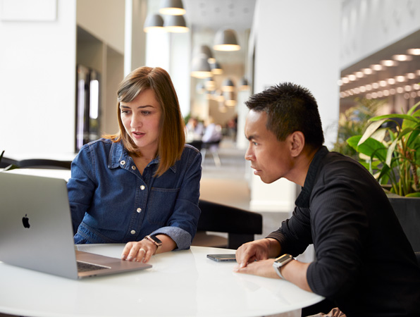 Apple Cork Support and Service employee talking with a coworker.