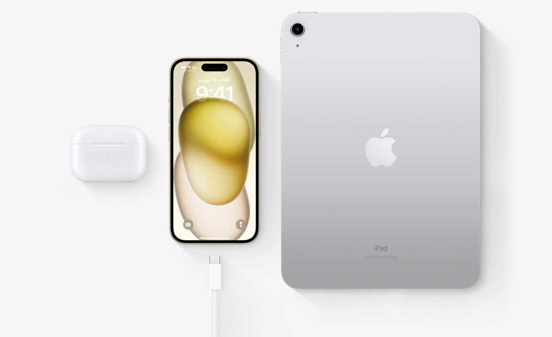 لقطة علوية لسماعات AirPods Pro وجهاز iPhone 15 وجهاز iPad بموصل USB-C لتوضيح كيفية شحن الأجهزة الثلاثة باستخدام كابل USB-C نفسه.